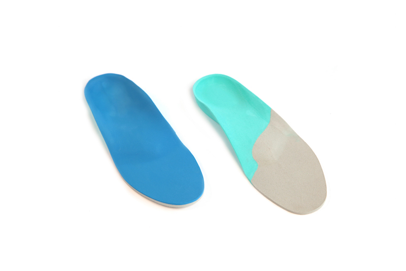 Twee orthopedische inlegzolen, blauw en groen.