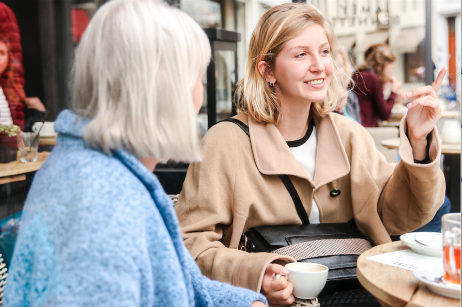 Twee vrouwen drinken koffie op een terras.